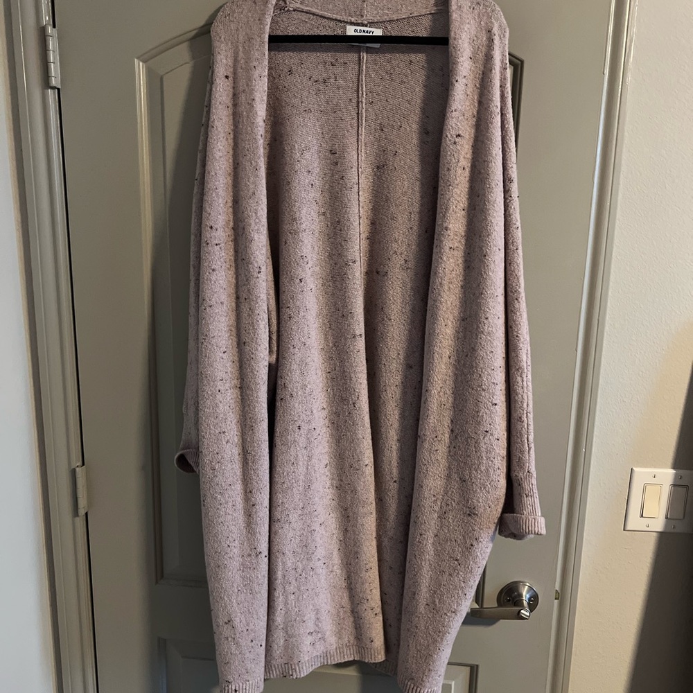 Long pink cardigan with dark blue speckles.